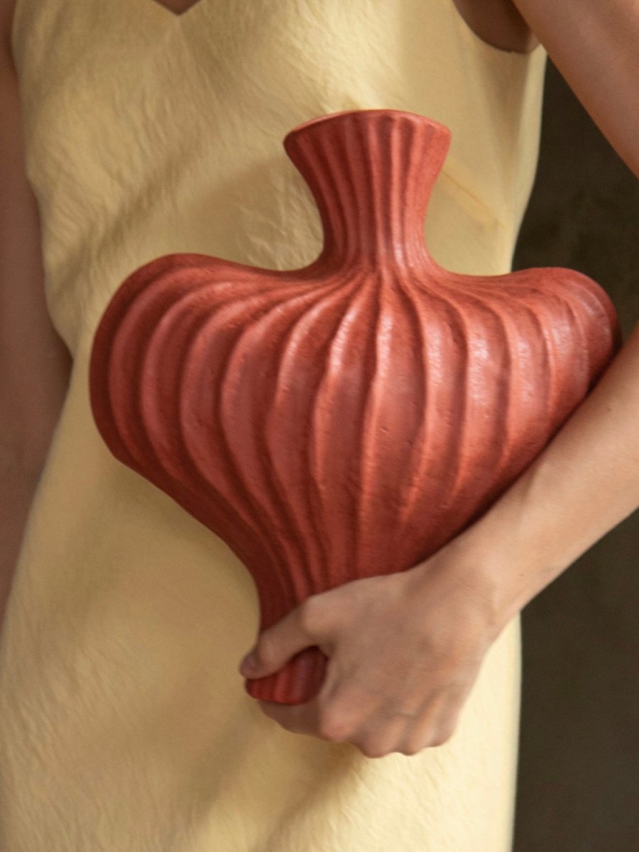 Red ceramic vase with wabi sabi aesthetic and rustic finish